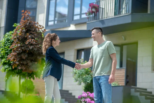 Elegant businesswoman in white pants shaking hands with a client