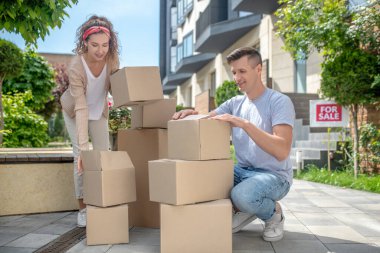 Genç çift yeni bir eve taşınmadan önce karton paketliyor.