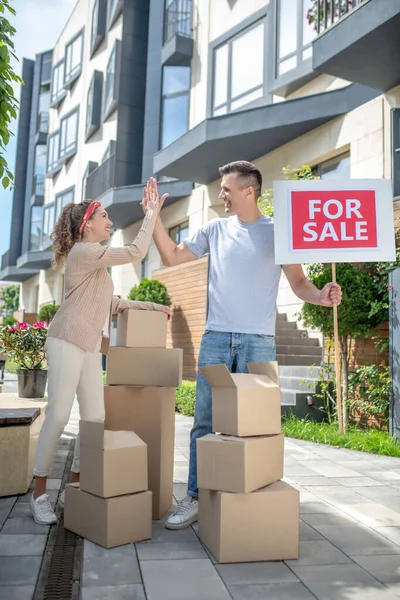 Sonriendo feliz pareja listo para mudarse a un nuevo apartamento y haciendo cinco — Foto de Stock