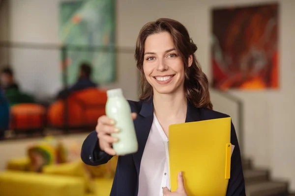 Mooie jonge vrouw in het kantoor met map — Stockfoto