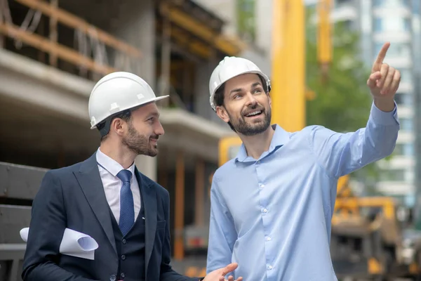 Foreman kezet fog, mutat valamit az építésvezetőnek. — Stock Fotó