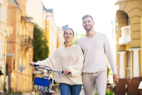 Woman with bike and tall man walking together — Stock Photo, Image