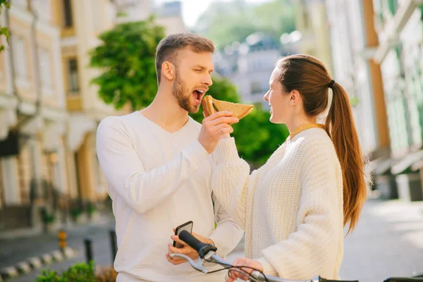 Homem e mulher com os olhos fechados alimentando uns aos outros sanduíches — Fotografia de Stock