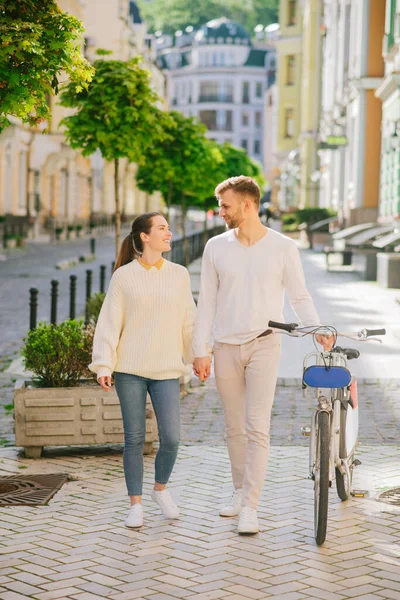 Energetikus fiatal férfi kerékpárral és nő sétál az utcán — Stock Fotó