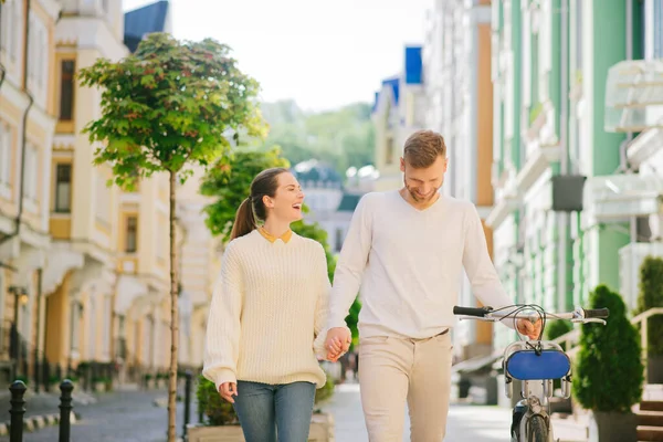 Riendo mujer y hombre con bicicleta corriendo por la calle — Foto de Stock