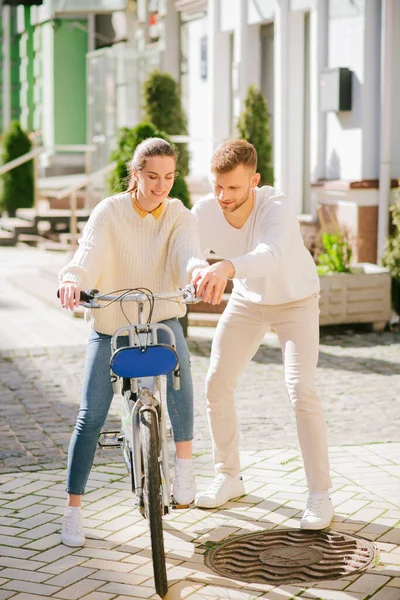 Mulher aprendendo a andar de bicicleta e um homem ajudando-a — Fotografia de Stock