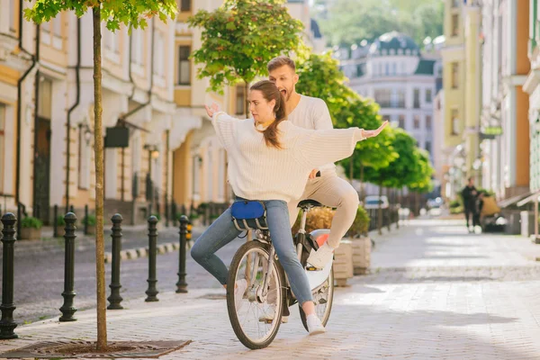 Wesoły mężczyzna i kobieta z grimaces jazdy na jednym rowerze — Zdjęcie stockowe