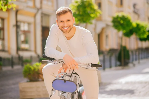 Junger Erfolgsmensch mit Fahrrad an Lenker gelehnt — Stockfoto