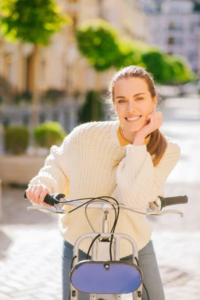 Glückliche junge Frau mit Fahrrad in der Stadt. — Stockfoto