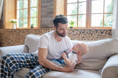 Genç, mutlu baba kucağında küçük oğlunu