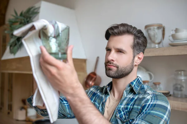 Joven con camisa a cuadros limpiando el vidrio — Foto de Stock