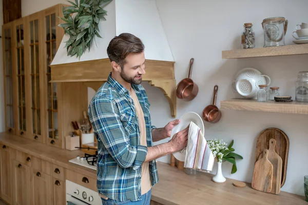 Jong in een geruit shirt veegt de beker af — Stockfoto