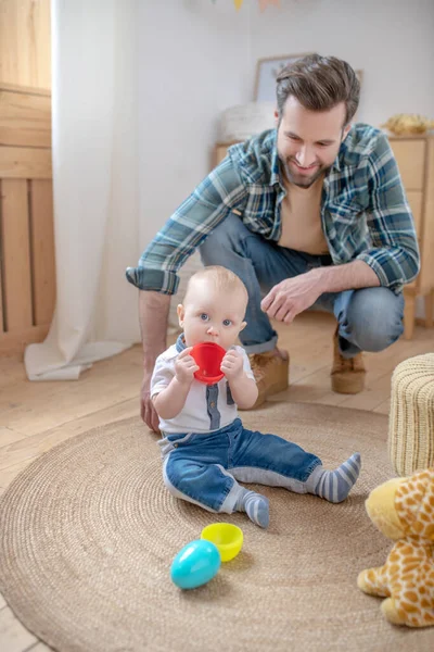Father in a checkered shirt sitting near his little son — Stock Photo, Image