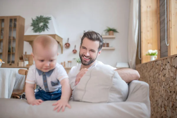 Unge far tittar på sin lille son och ler — Stockfoto