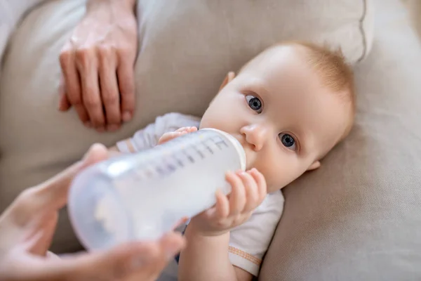 Fathers hands holding the bottle with milk for the baby — Stock Photo, Image