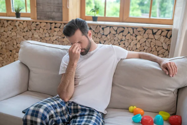 Jong gelukkig vader zitten op de bank gevoel uitgeput — Stockfoto