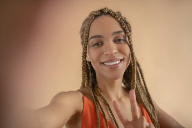 Gülümseyen genç Afrikalı Amerikalı kadın selfie yapıyor.