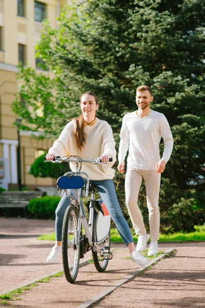Woman riding a bicycle and man running from behind. — Stock Photo, Image