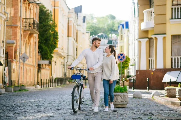 Мужчина с велосипедом и женщина, идущие глядя друг на друга — стоковое фото