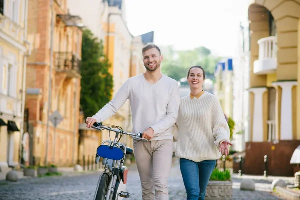 Hombre con bicicleta y mujer caminando alegremente por la calle — Foto de Stock