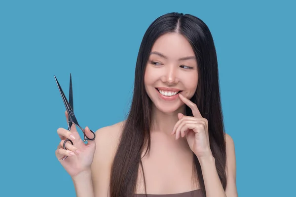 Sourire jeune femme aux cheveux longs penser à la coupe de cheveux — Photo