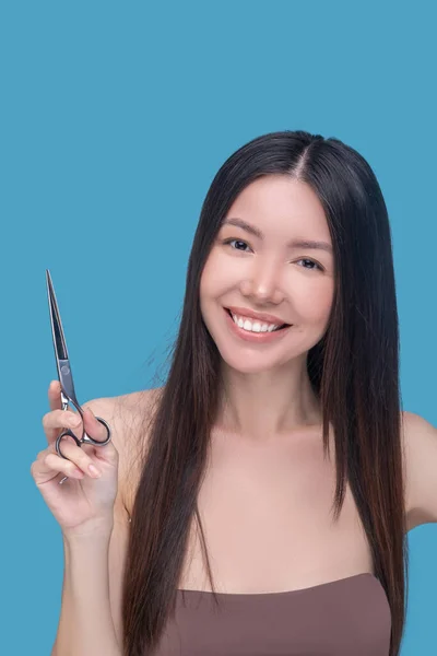 Mulher sorridente pensando em fazer um novo corte de cabelo — Fotografia de Stock