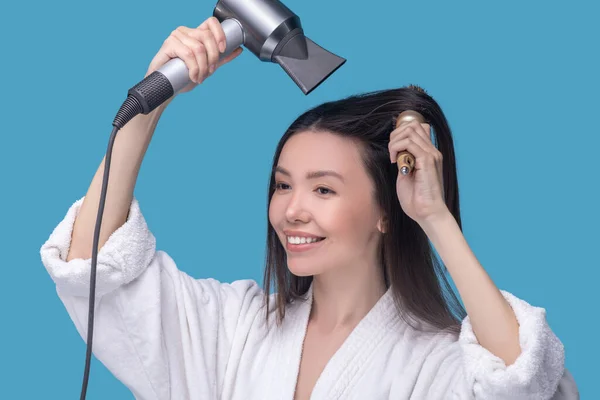 Mujer segura secándose y cepillándose el cabello — Foto de Stock