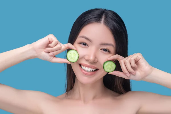 Gülümseyen kadın organik salatalık maskesi takıyor. — Stok fotoğraf