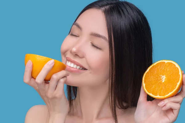 Mujer joven degustando una naranja jugosa fresca — Foto de Stock