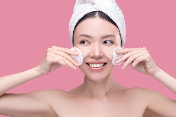 Mujer aplicando loción facial con almohadillas de algodón — Foto de Stock