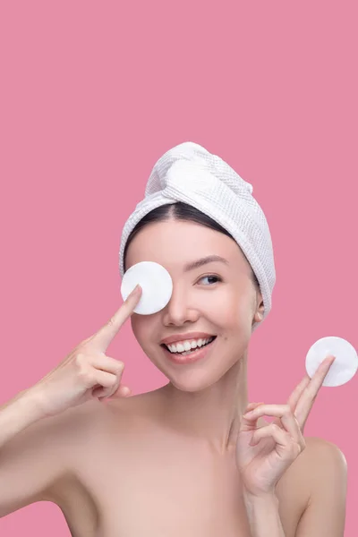 Woman playing with cotton pads while applying cosmetics — Stock Photo, Image