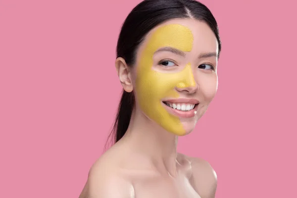 Glimlachende vrouw met een schoonheidsmasker op haar gezicht — Stockfoto