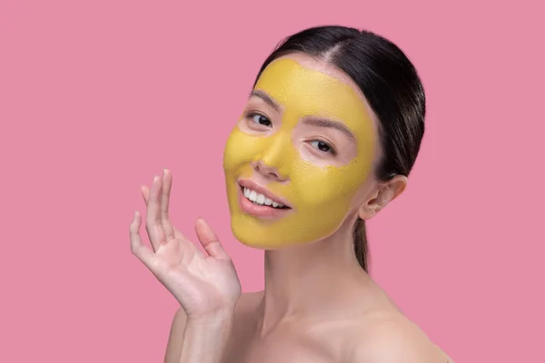 Wanita memiliki masker wajah emas sehari-hari — Stok Foto