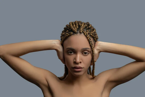 Frustrated young African American woman closing her ears with hands