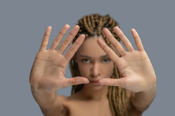 Triste jovem afro-americana mostrando as palmas das mãos para a câmera, tentando se proteger — Fotografia de Stock