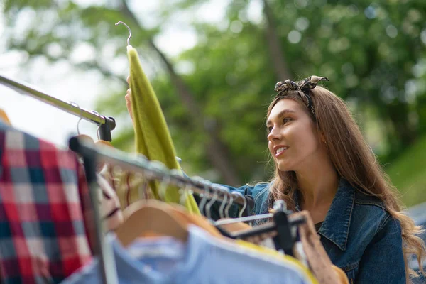 Schöne junge Frau auf der Suche nach Vintage-Kleidung — Stockfoto