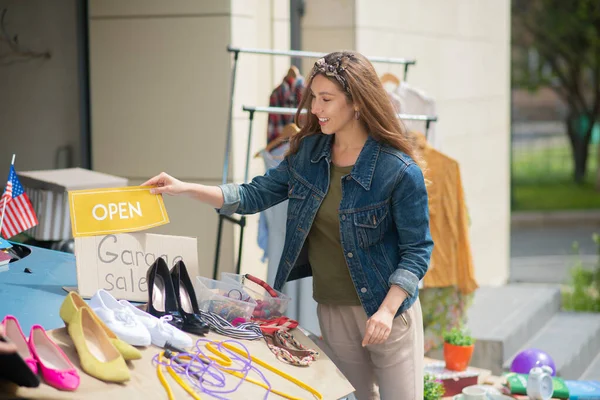 Cheerful young woman opening her own sale