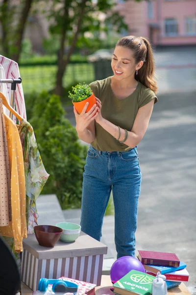 Happy young woman looking at the flower pot — Stock Photo, Image