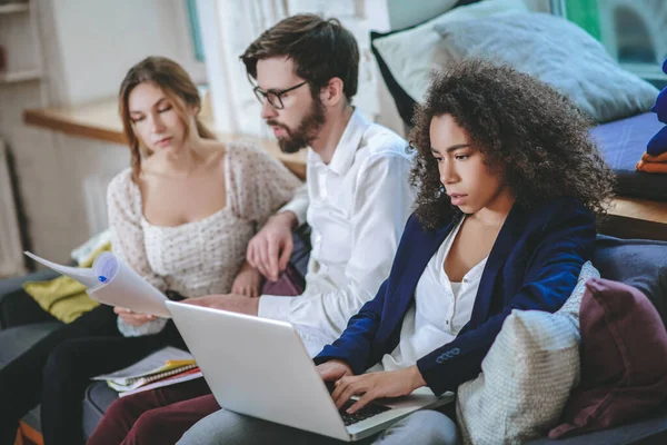 Mädchen arbeitet am Laptop, Freund und Freundin mit Dokumenten — Stockfoto