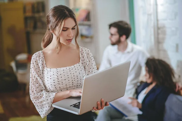 Grave involucrado chica de pie con portátil de trabajo . — Foto de Stock