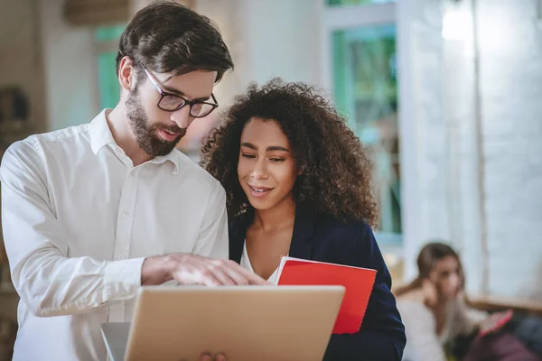 Chico con portátil mostrando pantalla a chica con portátil — Foto de Stock