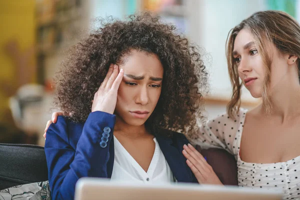 Fille avec les cheveux bouclés, visage très triste et petite amie étreignant son — Photo