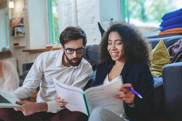 Chica sonriente con documento y chico sorprendido en gafas . — Foto de Stock