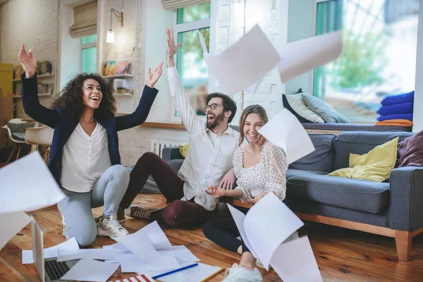 Fröhlicher Kerl und zwei Mädchen, die mit Papier werfen — Stockfoto