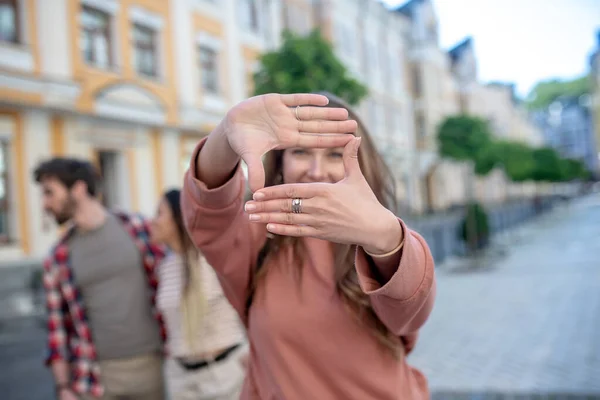 Mädchenhände basteln eine Luftlinse, die auf der Straße steht — Stockfoto