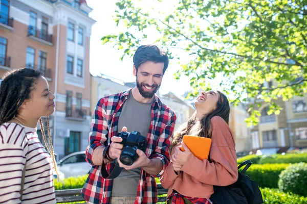 Pojkvän med kamera skrattande flicka kastade tillbaka sitt huvud och flickvän — Stockfoto