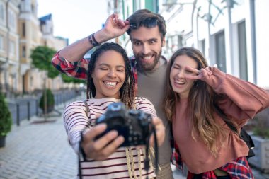 Kameralı Mulatto kızı erkek arkadaşı ve kız arkadaşıyla selfie çekiyor..