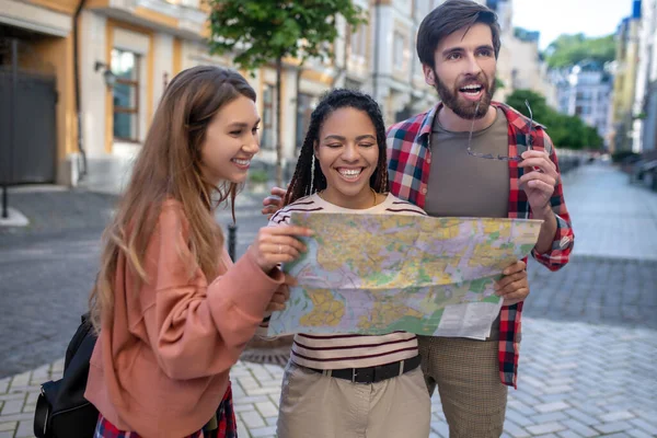 Three friends with map on city street — Stock Photo, Image