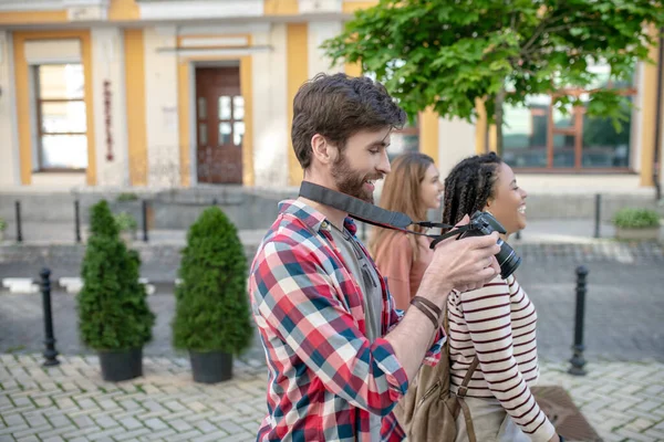 I profil ung kille med kamera och två flickor — Stockfoto