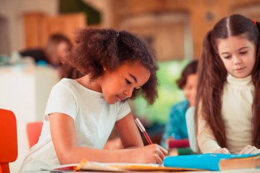 Özenli kız ödevini yazmaya odaklanmış.